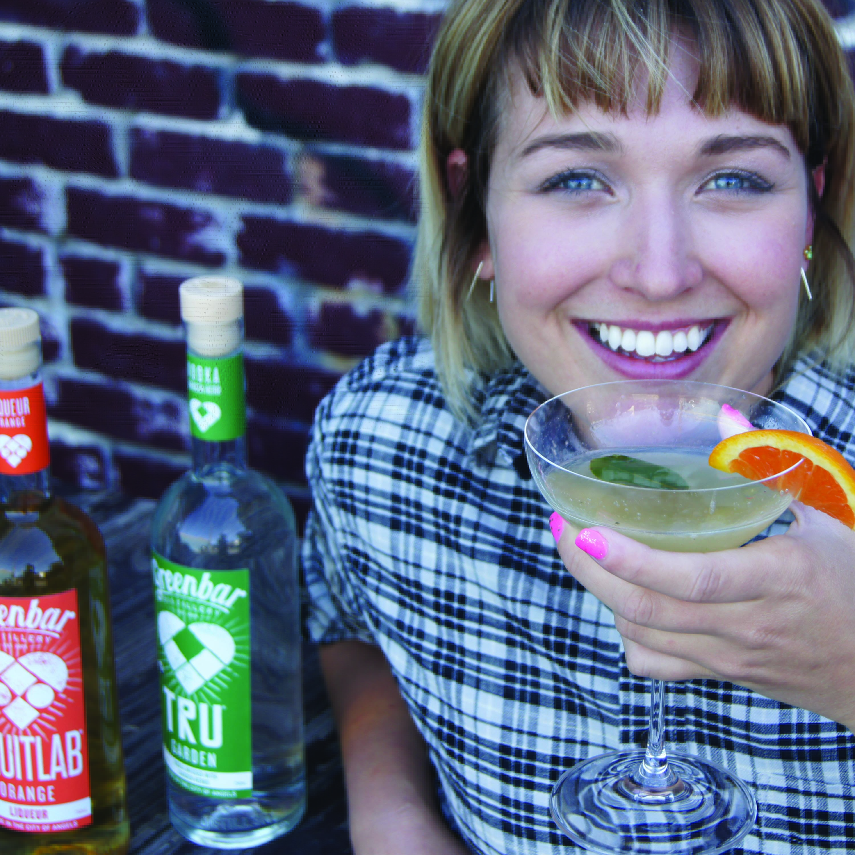 Woman holding cocktail featuring Greenbar Poppy amaro